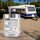 SCHUETTEC 2K Caravan-Lack 1,1 kg auf Campingplatz mit Wohnwagen mit blauen Zierstreifen im Hintergrund – Streifenlack für Wohnwagen, Caravan und Wohnmobil